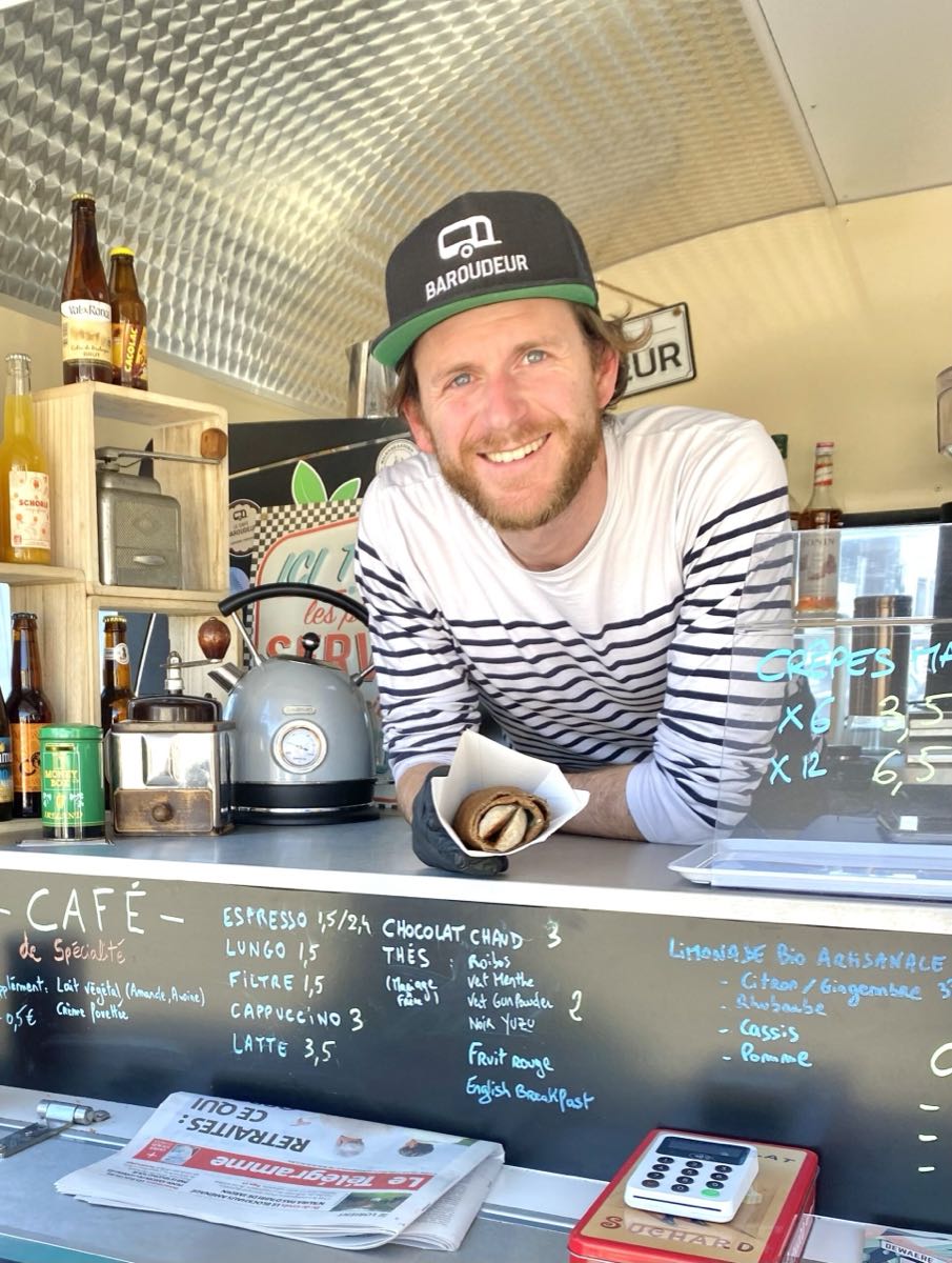 Kevin tend une crêpe roulée au comptoir de la caravane